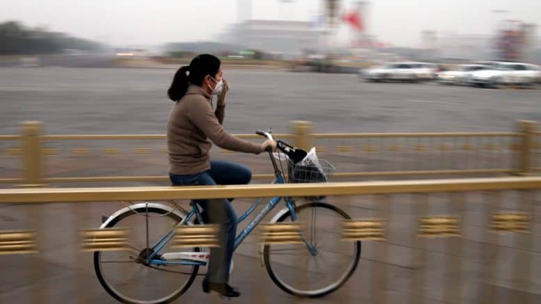 China - Frau - Person - Fahrrad - Mundschutz - Brücke - Fluss - Fahrradfahrerin - Peking - Fahrradkorb